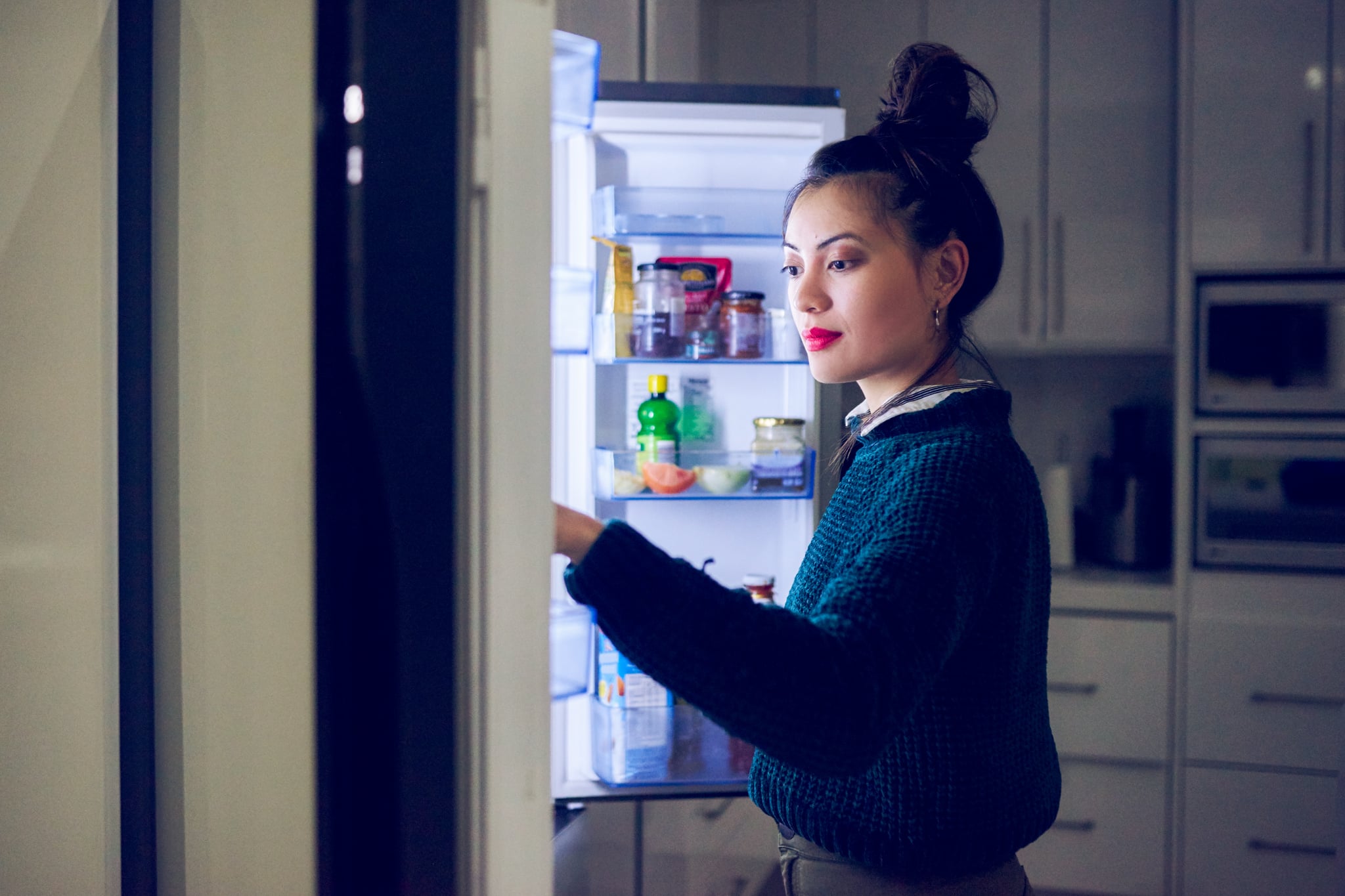 Cropped shot of an attractive young woman looking in her fridge for a midnight snack at home