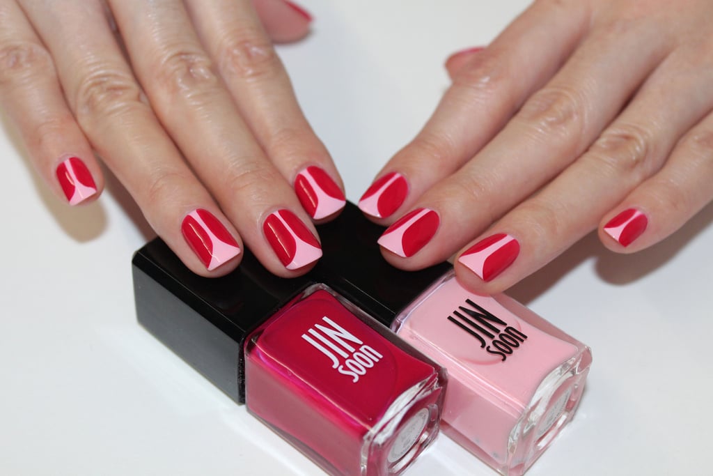 File and shape your nails to a natural square shape.
Apply a base coat like Jin Soon Power Coat ($18).
Apply Jin Soon Dolly Pink ($18) on the entire nail bed.
With a thin brush, create the tulip petals with Jin Soon Cherry Berry ($18).  Starting at the cuticle area, draw a straight line down toward the tip of the nail, curving left three-fourths of the way down to create an arch, and then fill in the shape. Repeat on the right side of the same nail to create a mirroring shape.
Apply top coat like Jin Soon Top Gloss ($18) for a lasting glossy finish.