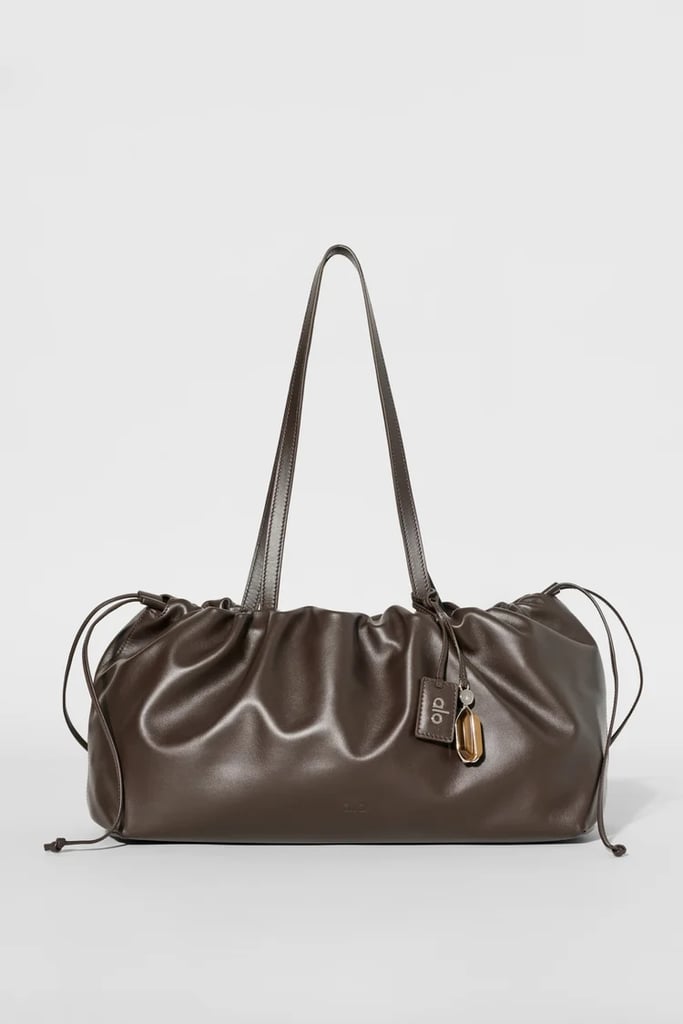 Alo Unwind Cinch Bag ($1,800)
Alo recently entered the accessories game by launching a line of bags under the brand's atelier category. While yes, these are not your average gym bags, each design maximizes fashion and functionality. My personal favorite is the Cinch Bag, which has a wide drawstring opening to store all of your essentials on the go. 
Pros: The voluminous silhouette and shiny leather feel and look like a designer bag
Cons: It is without a doubt an investment
Material: Leather
Dimensions: 8.65" H x 15.5" W x 16.125" L
Colorways: Three
Who It's Best For: Those looking for a luxury piece that is still practical