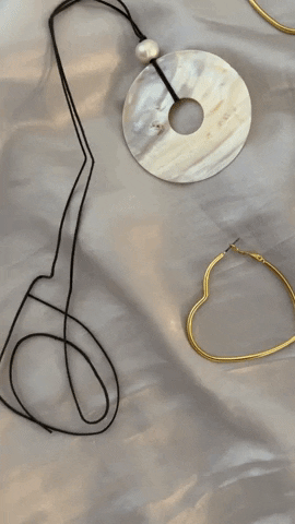 弗雷泽英镑耳环和项链项链平躺在丝绸上