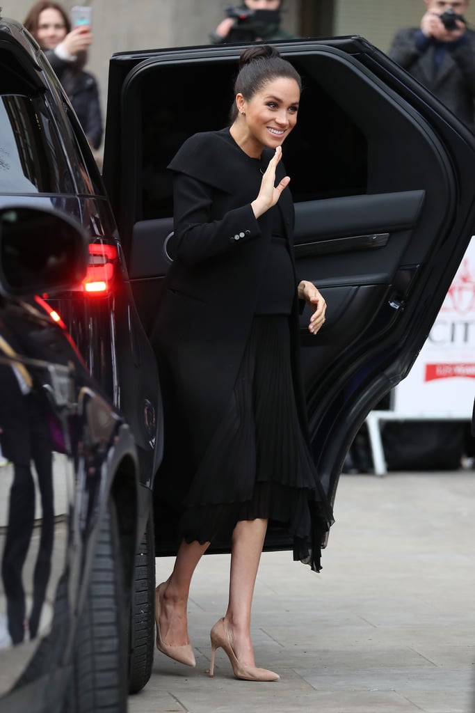 She teamed the coat with a black pleated skirt with an asymmetrical hemline, and beige pumps.