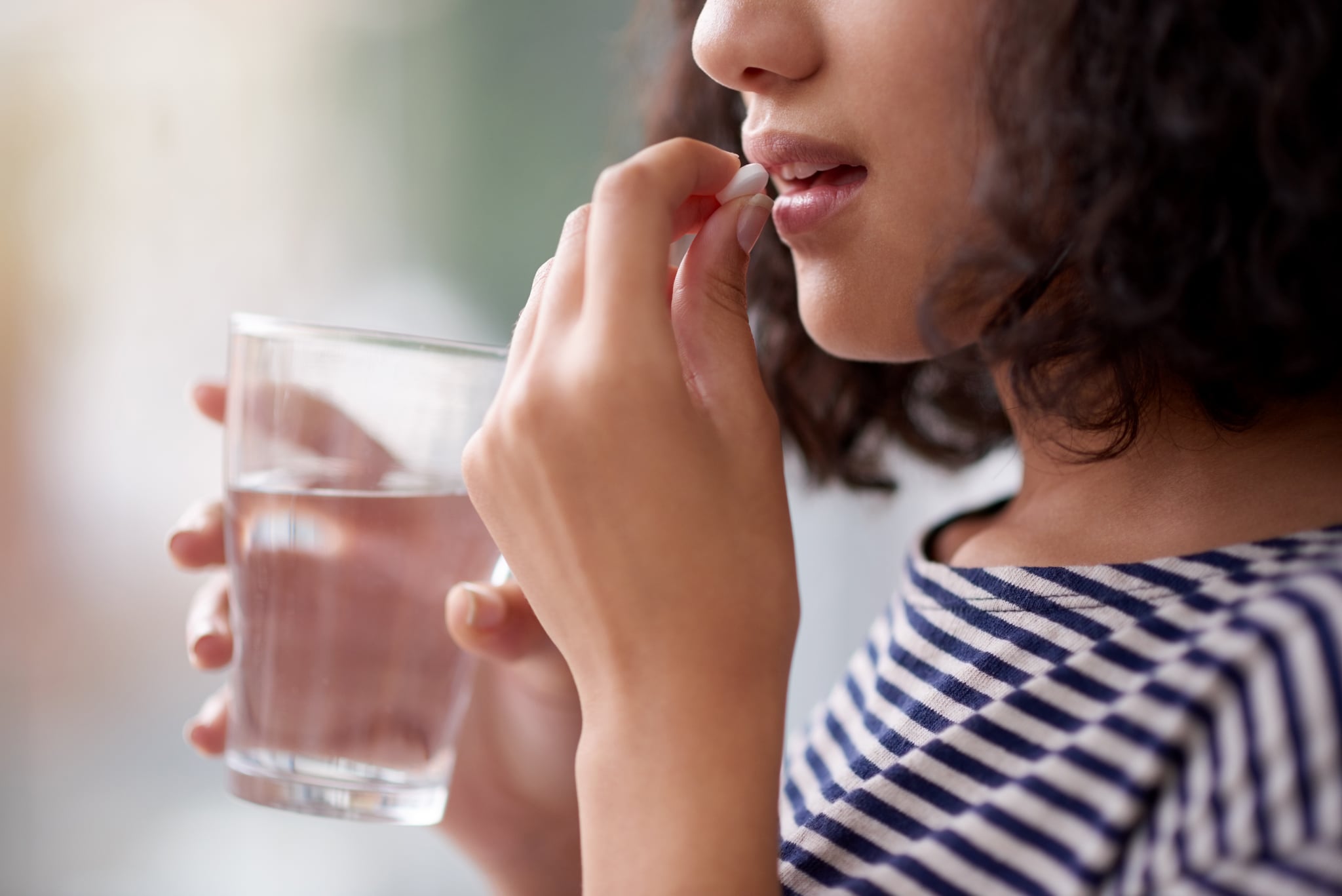 Cropped shot of an unrecognisable teenage girl drinking medication