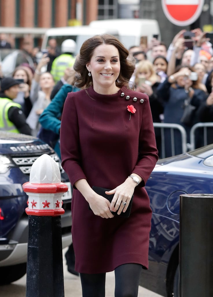 The Duchess of Cambridge was all smiles on Wednesday as she attended the annual Place2Be School Leaders Forum in London. The famous royal, who is currently expecting her third child with Prince William, gave a glimpse of her growing belly as she wore a plum tunic dress and a poppy ahead of Remembrance Day on Nov. 11. Aside from mingling with guests, Kate also took to the stage to talk about the importance of children's mental health. 
It certainly seems like the royal is feeling like her old self again. After missing Prince George's first day of school due to hyperemesis gravidarum, Kate revealed that she is feeling well enough now to drop her son off at Thomas's Battersea School. "As a mother, just getting used to leaving my own child at the school gates, it is clear to me that it takes a whole community to help raise a child," she said during the forum. "Whether we are school leavers, teachers, support staff or parents we are all in this together." Hopefully, there will be even more sweet moments with Kate and her family as we approach the festive period.