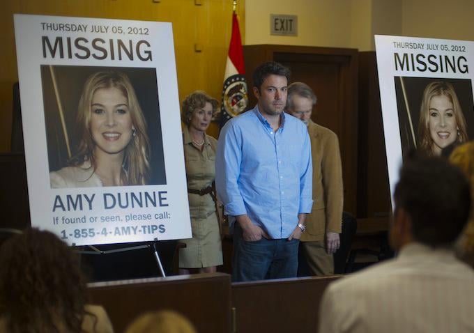 Nick poses in front of the "Missing" posters.