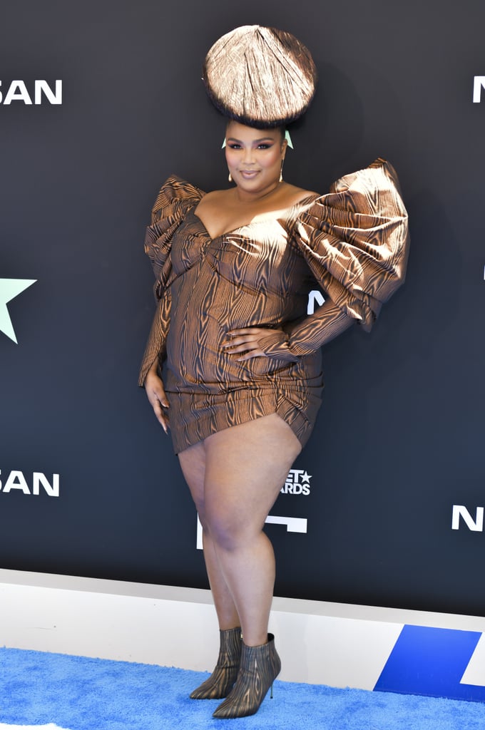 Lizzo absolutely stunned in this wood-print minidress, which she accessorized with a matching hat, boots, and nails. It's truly an ensemble.