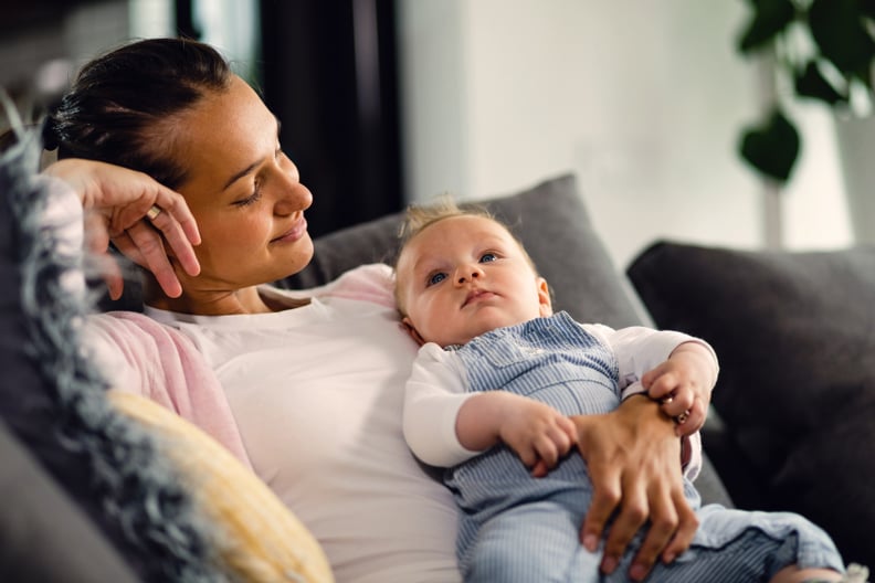 Smiling Babysitter Holds Baby While Looking at Him