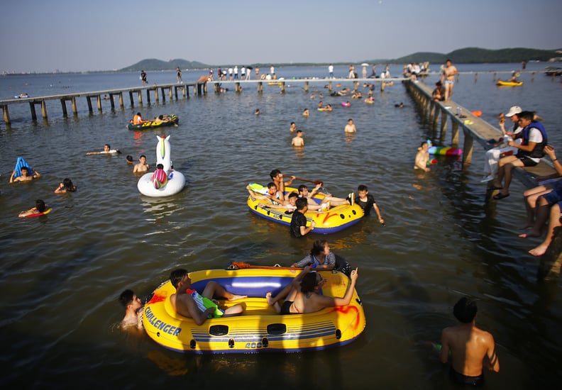 WUHAN, CHINA - JULY 24:  Residents enjoy the water in East Lake of Wuhan, Hubei province, China, July 25, 2016. This activity, which requires participants to ride their bikes and jump into the lake, attracts many extreme cycling enthusiasts from the city,