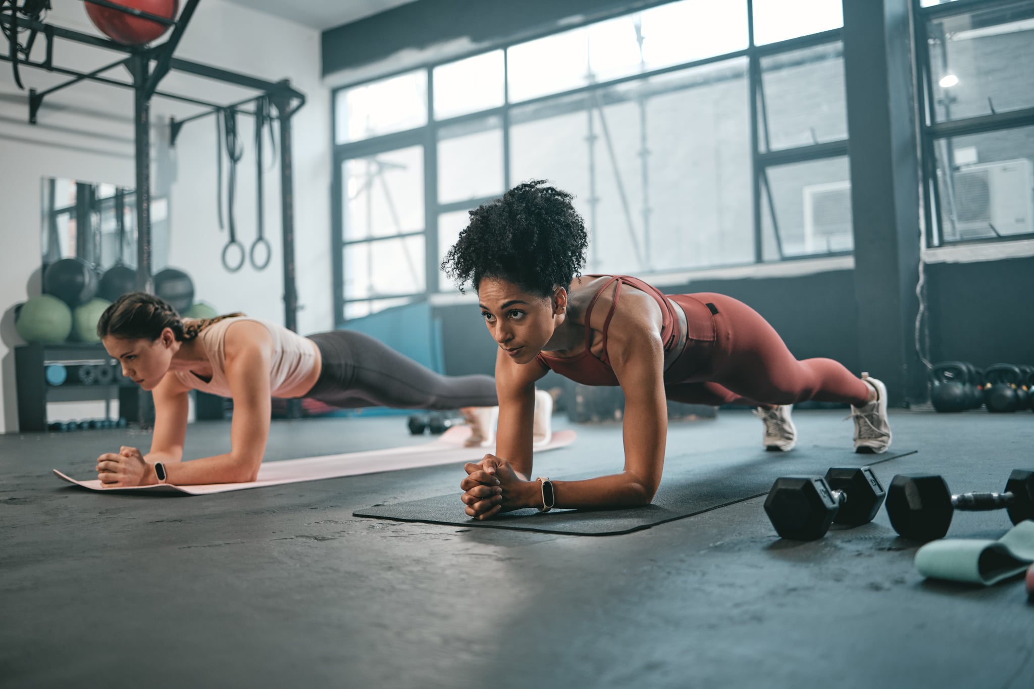 Women, plank and gym fitness friends  with cardio exercise, workout and body wellness. Motivation, woman focus and challenge of people in sports training and athlete class exercising for health