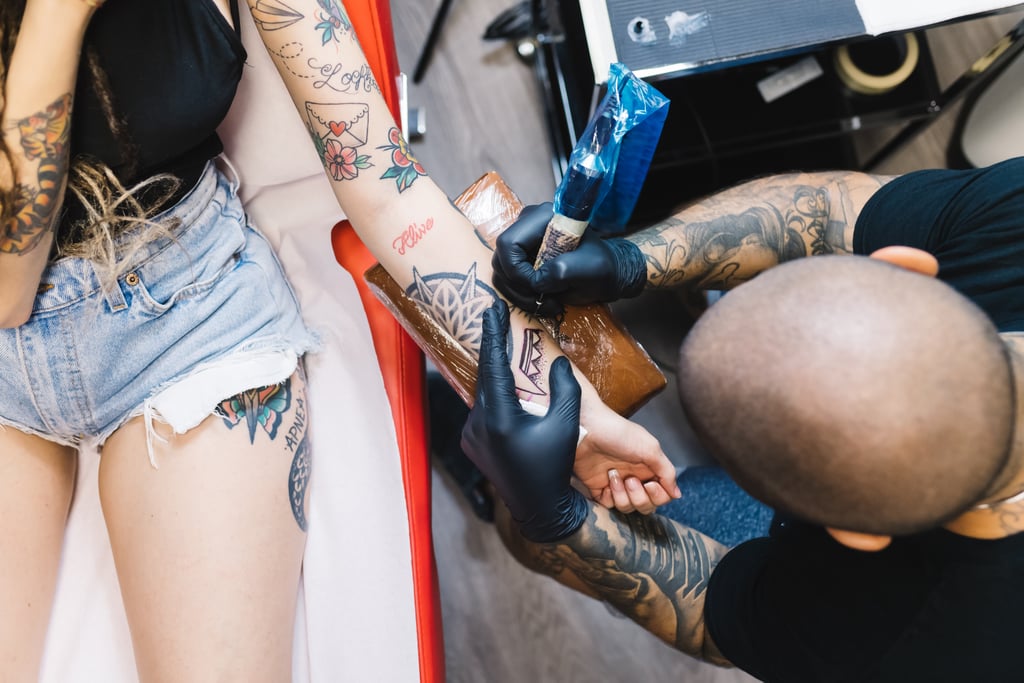 How Should I Take Care of My Tattoo Right After Getting It?
Other than regularly applying SPF once that ink is fully healed, you should also make sure you're properly cleaning it. 
"Brand-new tattoos need to be kept clean," Dr. Love said. "Activities to avoid after getting a new tattoo include anything that would expose it to potentially harmful bacteria, such as public pools and lakes, public gyms, and beaches."
How Long Should I Keep My New Tattoo Out of the Sun?
During the first week of having your new tattoo, Dr. Love said that you should consider wearing baggier clothing as a way to comfortably keep it covered up. Later on, you should definitely make sure to wear (or continue to wear) sun protection all over your body, but especially over the tattoo.
"Once a tattoo does heal, you can use sunscreen and also wear a UV sleeve, but only when it is fully healed," Caranfa said. "Keep your tattoo in the shade."