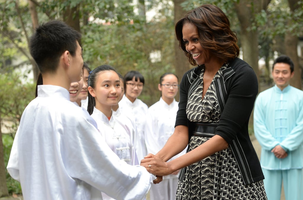 The first lady shook hands with one of the students after performing tai chi with them at a Chengdu high school.