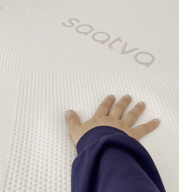 GIF of a hand pressing down on the Saatva Graphite Memory Foam Topper