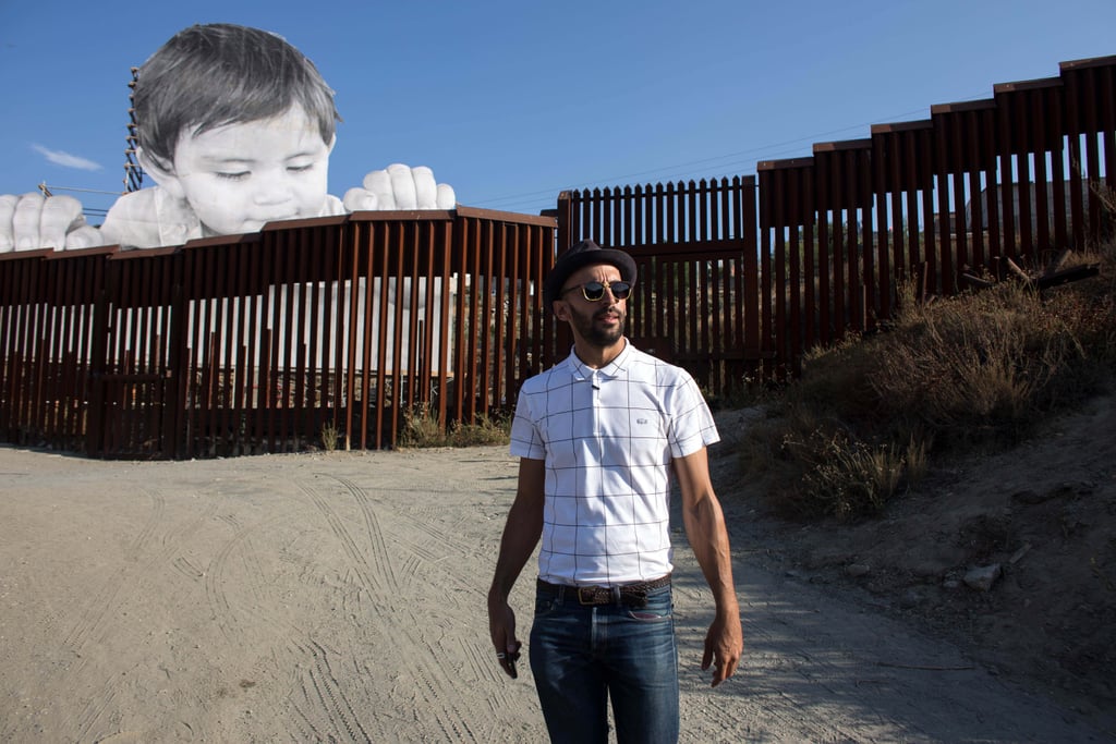 JR posed in front of his artwork. Mexico Border Wall Art Installation