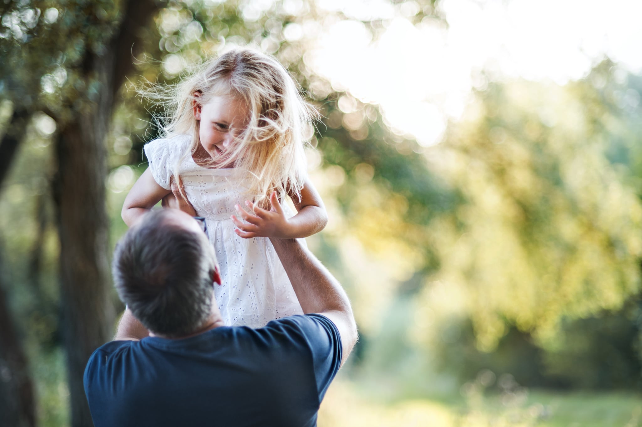 A man standing with a small girl, holding her. Copy space.