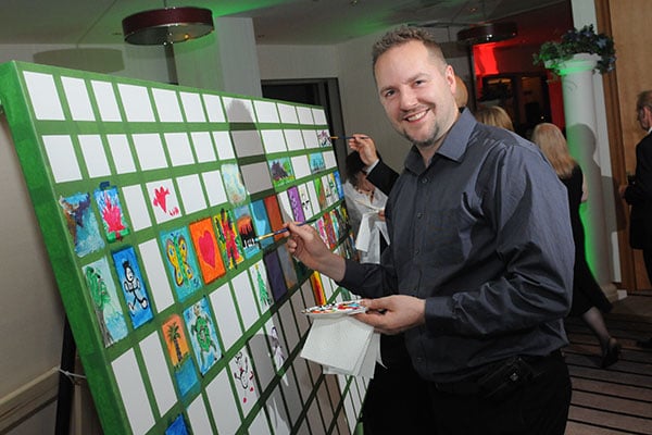 Get guests' creative juices flowing by setting up a community canvas where everyone can paint one quadrant. Afterward, you can keep the backdrop as a memento of your big day.