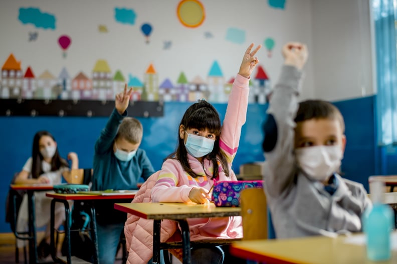 小学的学生在教室里戴着防毒面具。教育在流行。