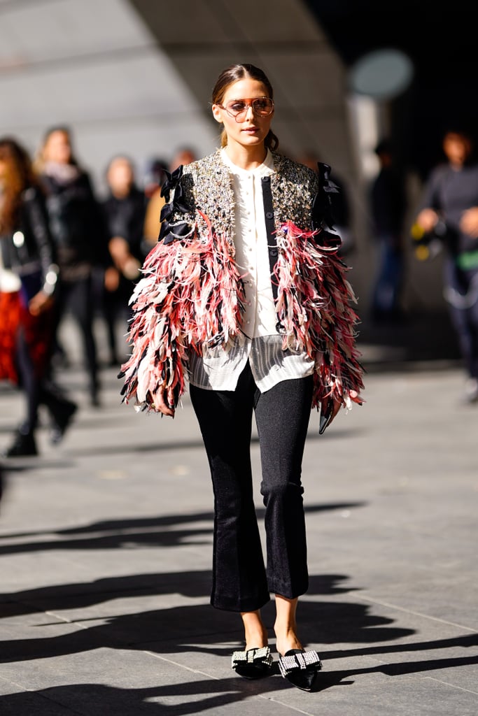 During the Paris shows, Olivia turned the sidewalk into a runway with this feather-trimmed and embellished jacket to top black pants and bow-adorned flats.