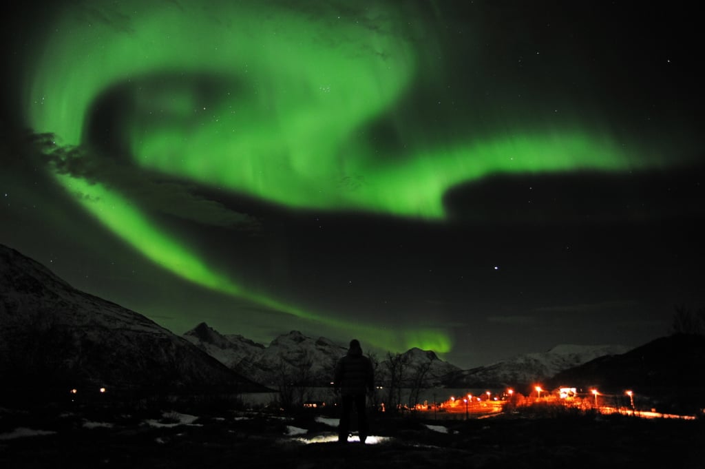 A man checked out the northern lights near the city of Tromsoe, Norway, in January 2012.