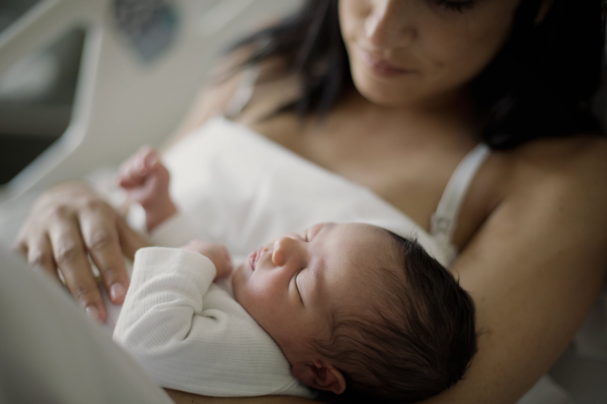 Newborn girl sleeps in her mom arms at hospital Sant Pau from Barcelona