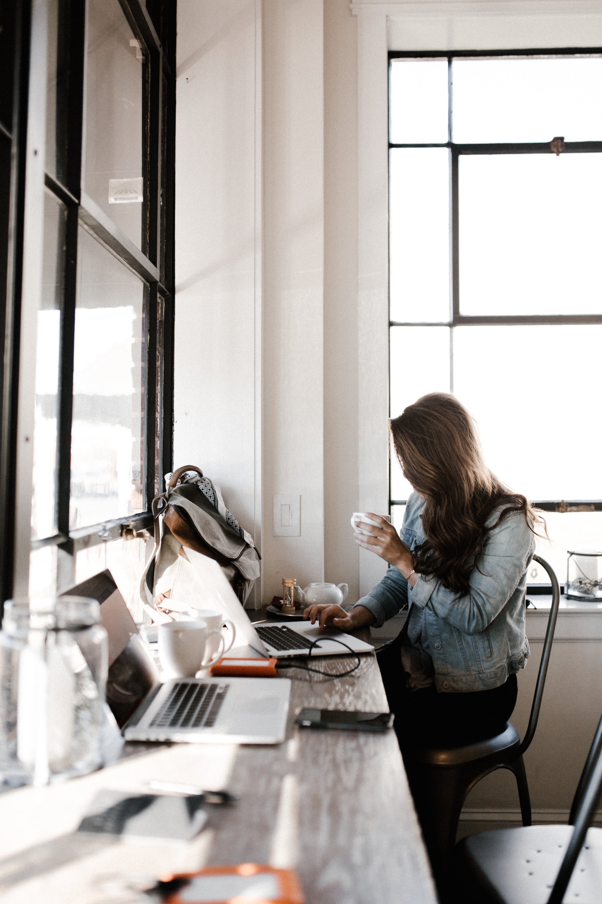 woman sitting at messy desk symbolic of the August 2022 new moon in Virgo