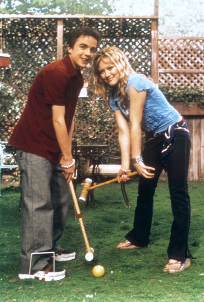 Playing bocce ball in a ruffled blue top and jeans with a scarf tied around the waist.