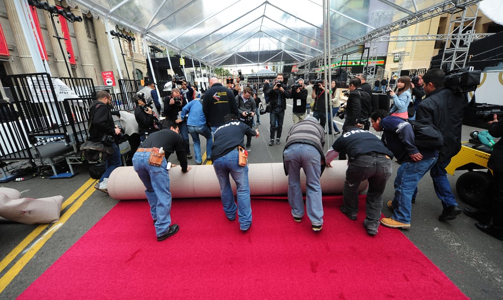 It takes five guys to roll out the giant red carpet.
