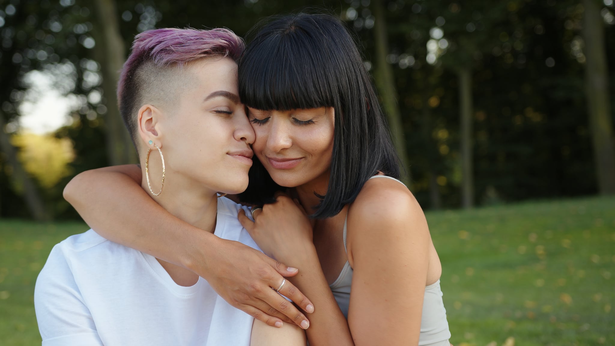 Portrait of happy lesbian LGBT women in the park.