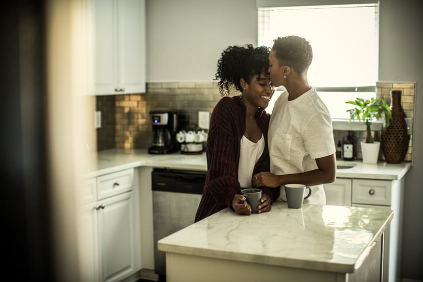 couple kissing in a kitchen enjoying coffee together as a free thing to do on Valentine's Day