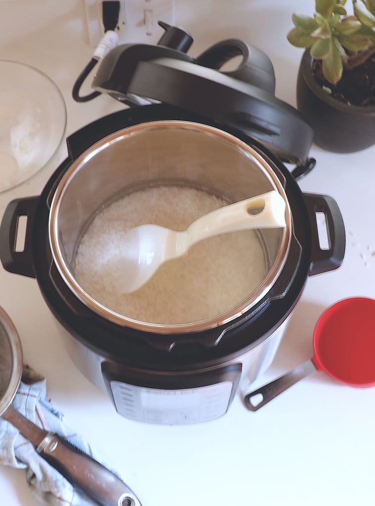Add the rice to the Instant Pot with two cups of water. Make sure there aren't any stray grains above the water line, as they'll burn. 
Note: This 1:1 rice and water ratio is for white rice. If you're using brown rice, you'll need two and a half cups of water for two cups of rice.