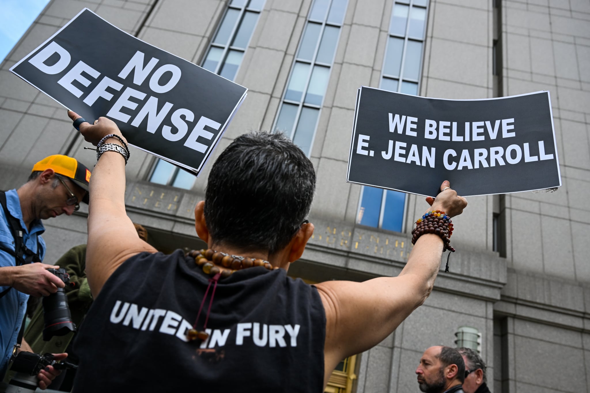 NEW YORK, NEW YORK - MAY 09: : A protester holds up signs outside a Manhattan Federal Court after a jury found former President Donald Trump liable for sexually abusing E. Jean Carroll in a Manhattan department store in the 1990's on May 09, 2023 in New York City. The jury awarded her $5 million in damages for her battery and defamation claims. Carroll has testified that she was raped by former President Trump, giving details about the alleged attack in the mid-1990s. Trump had stated that the attack never happened and has denied meeting her. He did not taken the stand during the trial. (Photo by Alexi Rosenfeld/Getty Images)