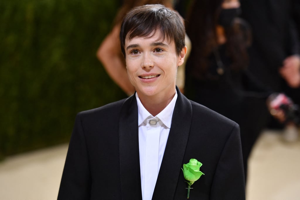 Elliot Page looked effortlessly cool at the Met Gala on Monday. The actor wore a black Balenciaga suit and chunky sneakers, also by the brand, for his first-ever appearance at the famous fashion event. It was his boutonnière, however, that caught our attention, and added some symbolism to the otherwise understated outfit. 
The green rose pinned to Elliot's suit is widely being interpreted as a nod to Oscar Wilde. The poet and playwright famously had one of his actors wear a green carnation on opening night of his 1892 comedy Lady Windermere's Fan. He also had several of his friends wear green carnations on their lapels as well. Being that Oscar was believed to be gay, and prominently featured gayness as a theme in his work, the green carnation has since been claimed as a symbol for gay men and queerness, more generally. 
The high-profile outing was a significant one for Elliot, who publicly came out as transgender in December 2020. In an interview with Time a few months later, Elliot spoke about previously struggling with dressing for red carpet events. "I just never recognized myself," he said. "For a long time I could not even look at a photo of myself."

    Related:

            
            
                                    
                            

            Black Designers Are Having a Big Night at the Met Gala, and I&apos;m So Here For It