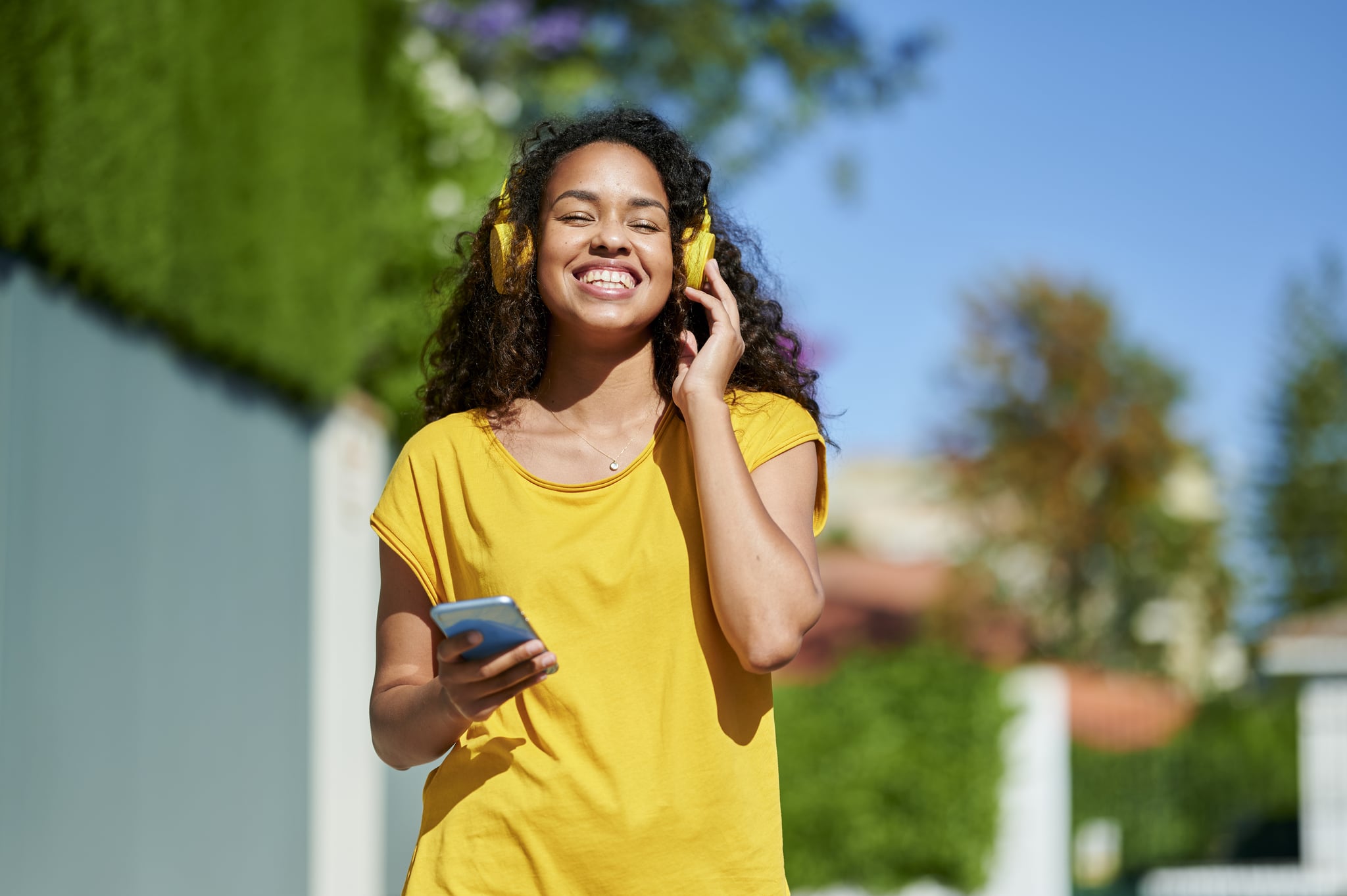 Woman with smartphone and headphones taking a hot girl walk