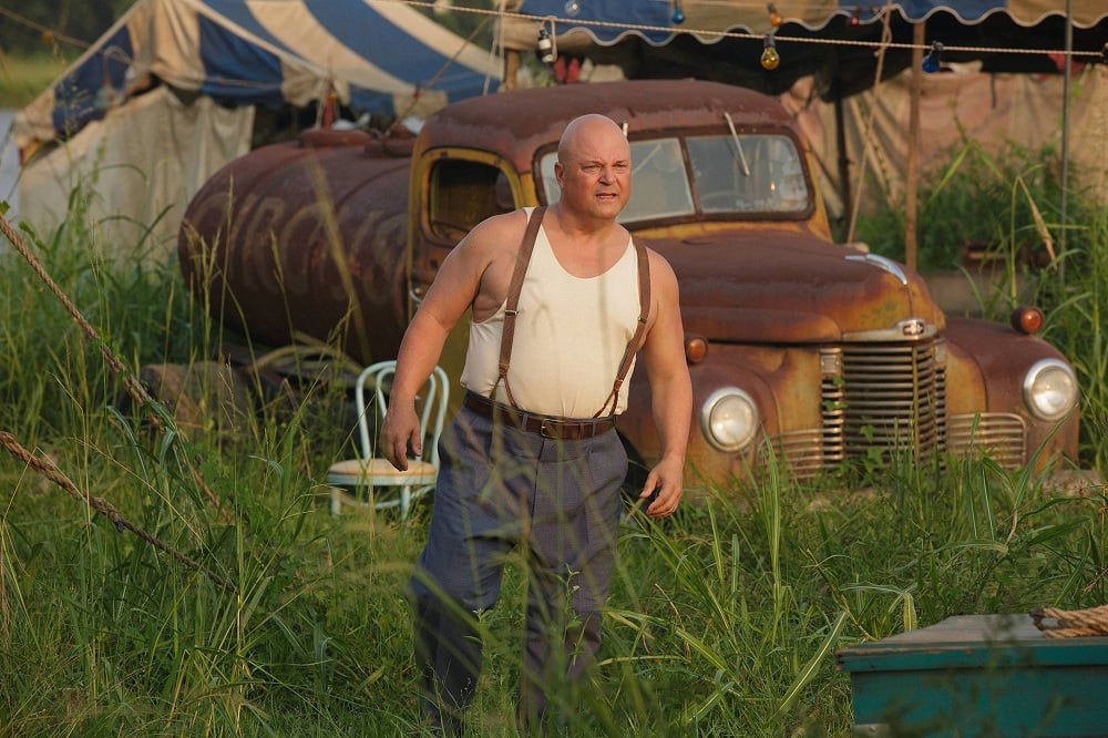 Dell rocks a white tank top and some suspenders. Classic sideshow look.