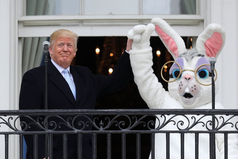 WASHINGTON, DC - APRIL 02:  AFP OUT U.S. President Donald Trump (L) lifts the hand of a person in an Easter Bunny costume on the Truman Balcony during the 140th annual Easter Egg Roll on the South Lawn of the White House April 2, 2018 in Washington, DC. T