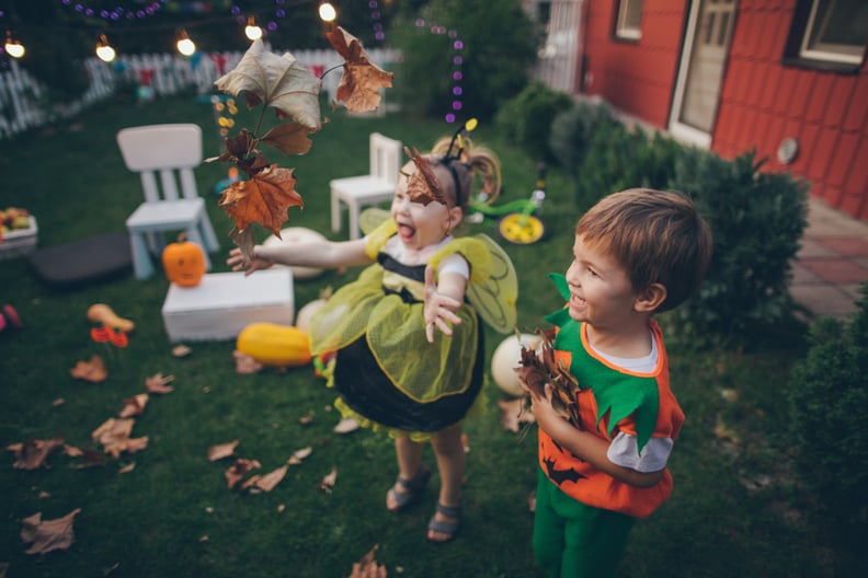 Little boy and little girl having fun in the backyard during the Halloween