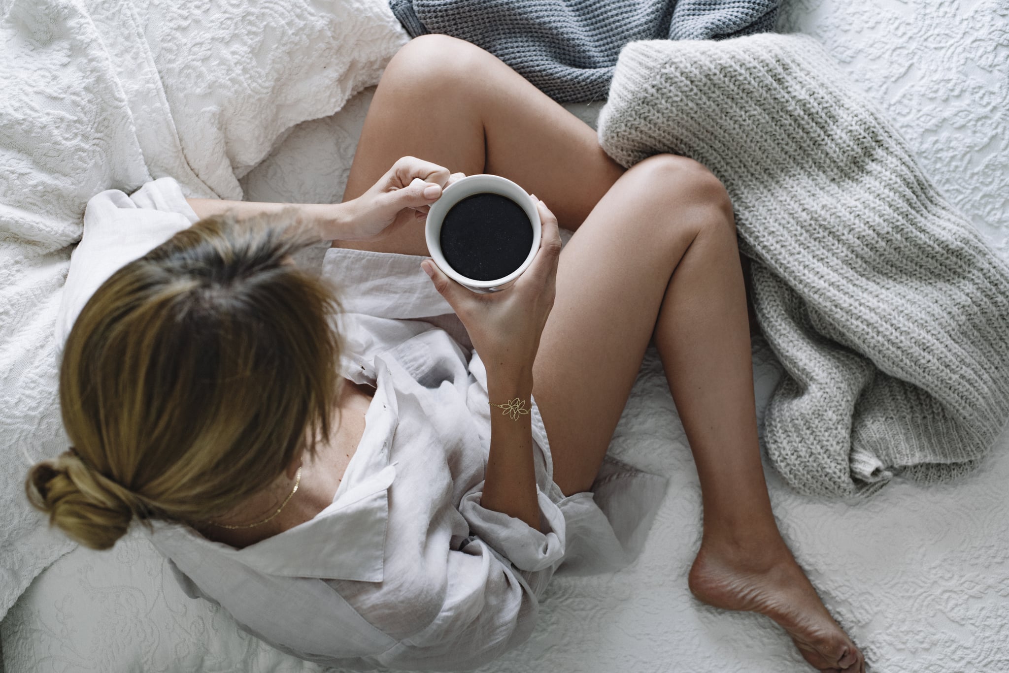 Warm and Cozy mood with white blankets, cozy sweaters and coffee