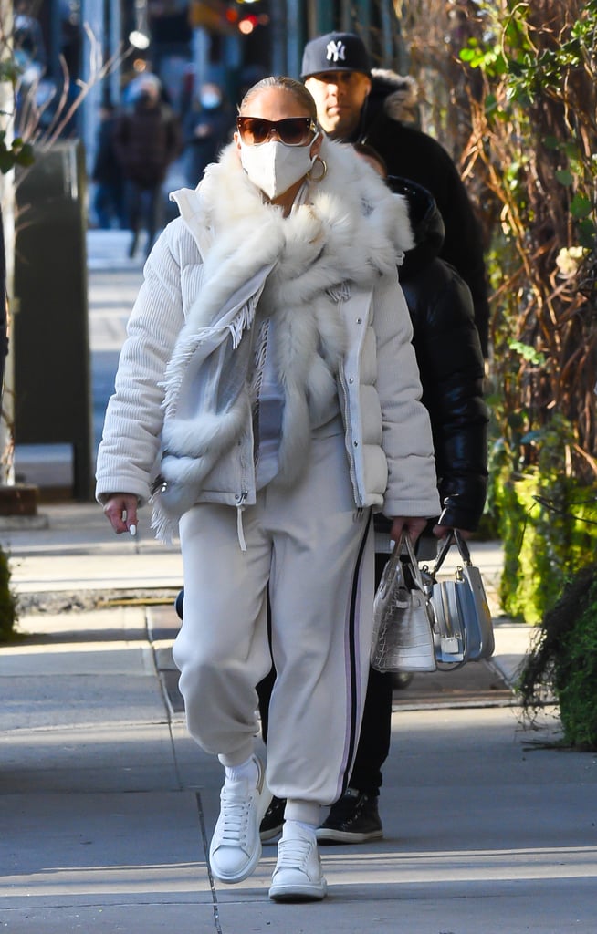 Wearing a cream sweatsuit with a puffer and a fuzzy scarf.