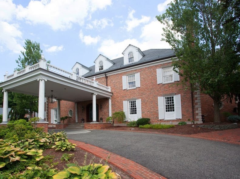 The outside of the house features a long, winding driveway.