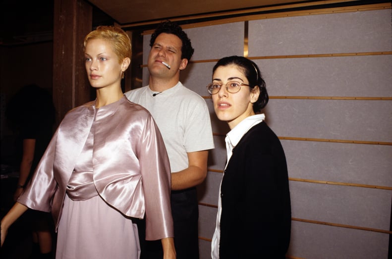 纽约- 10月30日:美国时装设计师Isaac Mizrahi(中心),照了照镜子,斜眼而调整自己设计的衣服穿的美国模式卡罗琳·墨菲(左)在拟合在他展厅10月30日,1995年在Soho, Ne