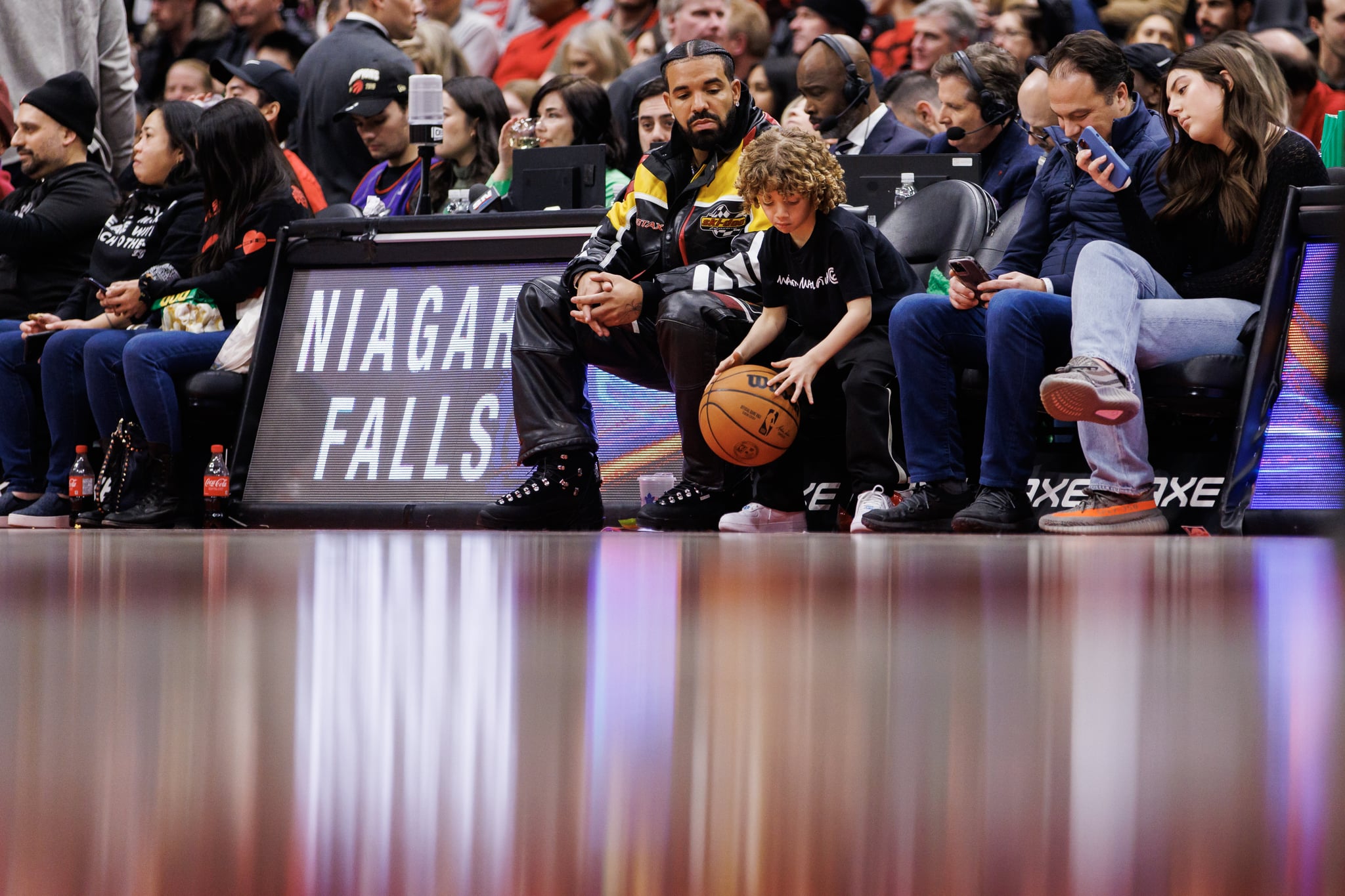 TORONTO, ON – 27. DEZEMBER: Rapper Drake beobachtet, wie sein Sohn Adonis in der zweiten Hälfte des NBA-Spiels zwischen den Toronto Raptors und den LA Clippers in der Scotiabank Arena am 27. Dezember 2022 in Toronto, Kanada, einen Basketball dribbelt.