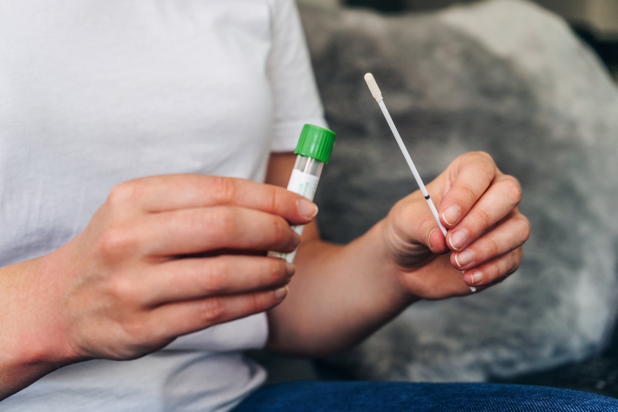 Young woman  holds a swab and medical tube for the coronavirus / covid19 home test