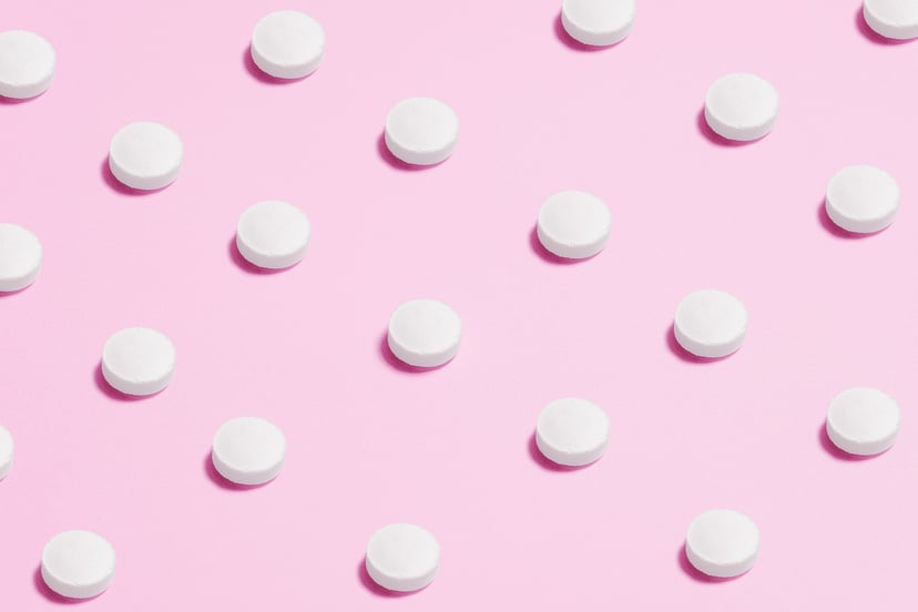 White Plan B pills on pink background