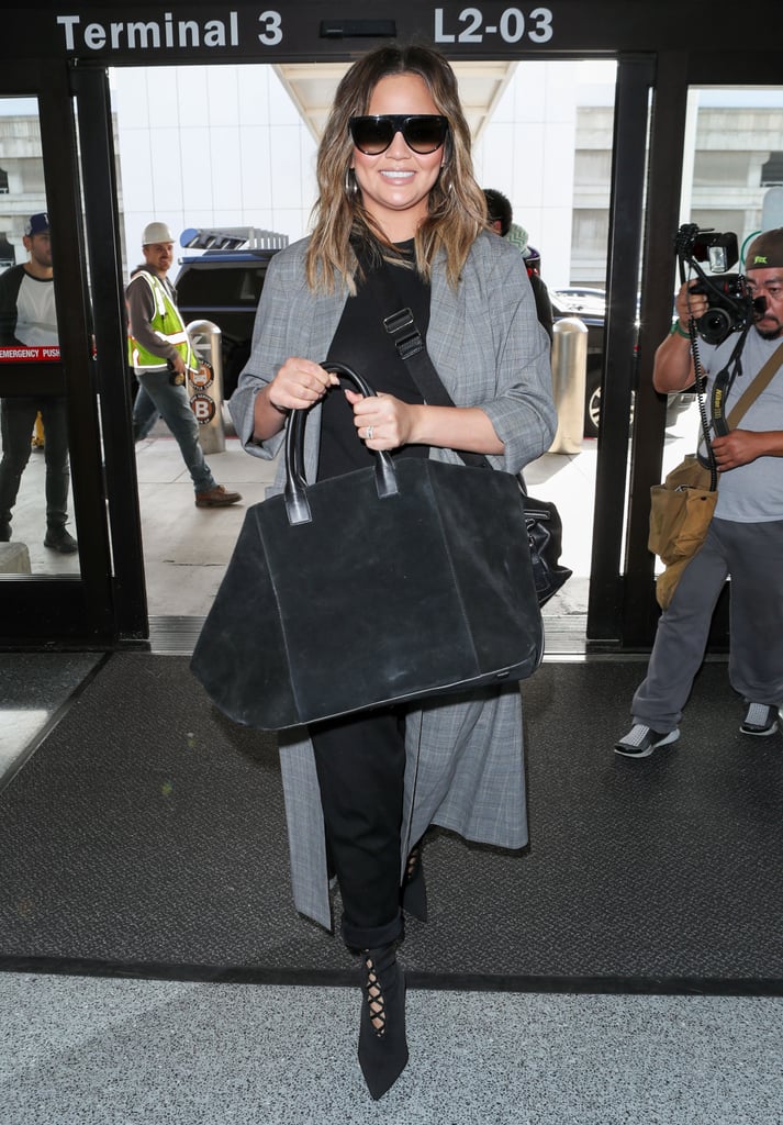 Chrissy Teigen Wearing Black Stiletto Booties at Airport