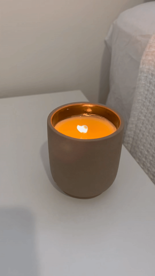 A gif of Homecourt's Cece candle burning on a side table.