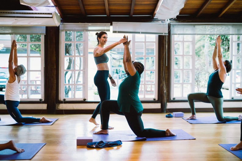 Group of mature women having yoga class while being trained by a teacher.