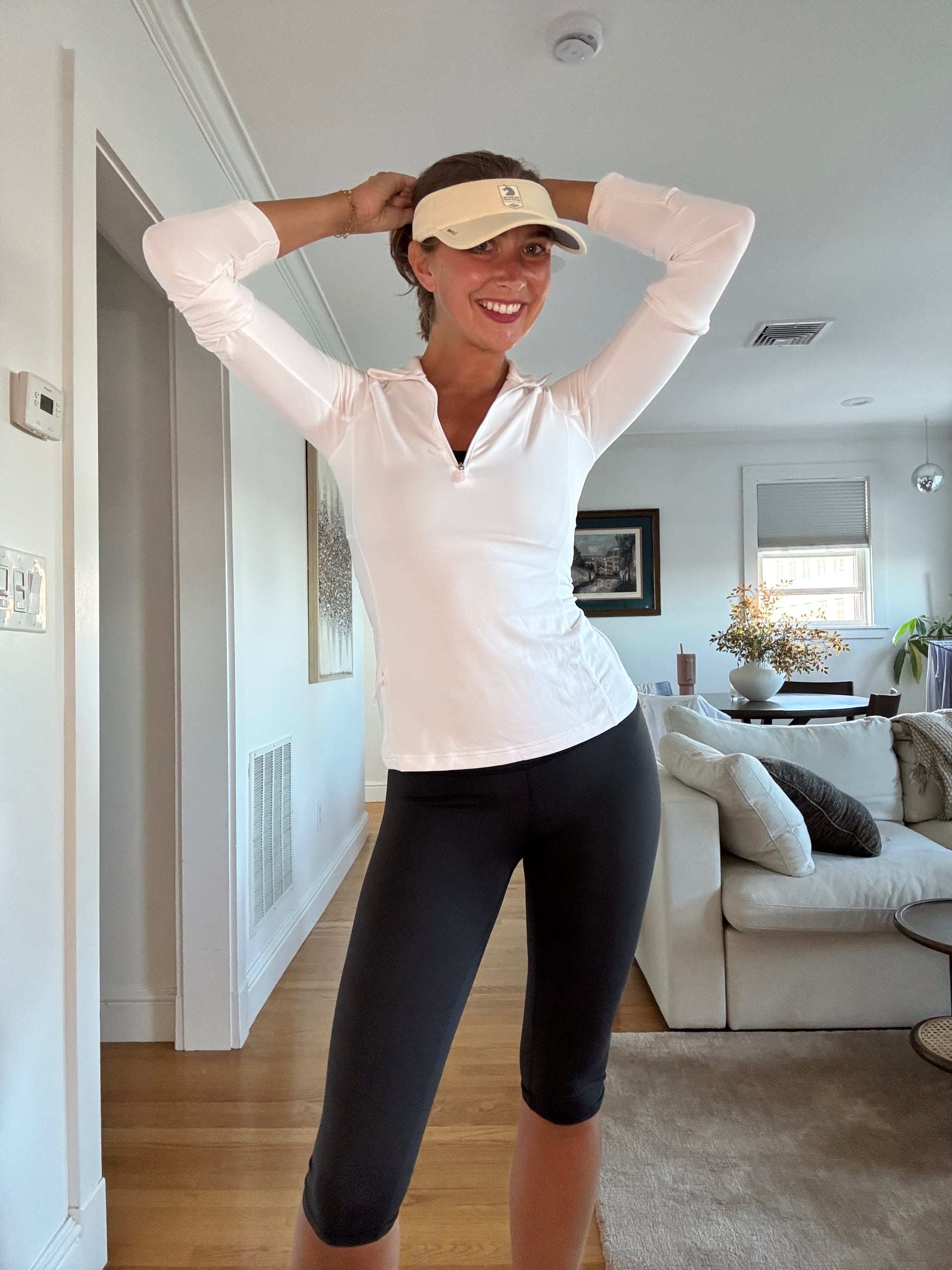 Woman wearing a white half zip and black leggings