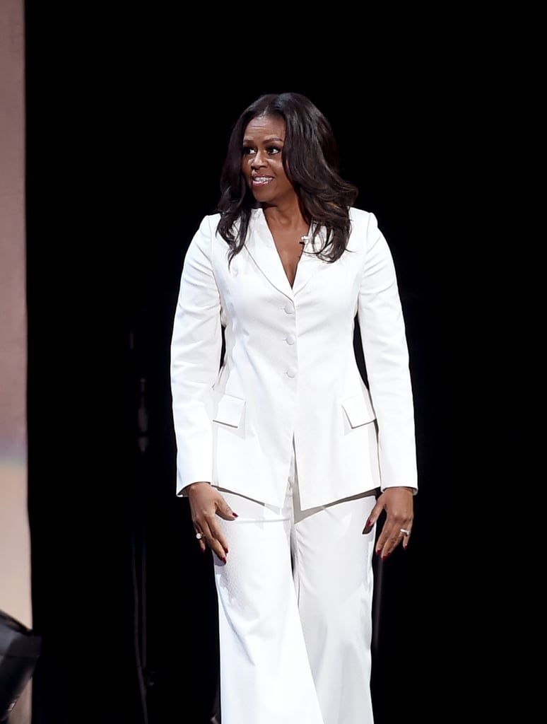 Michelle wore this white custom Christian Siriano look for an appearance at The Forum in Inglewood, CA. She accessorized the outfit with white pumps and statement earrings.