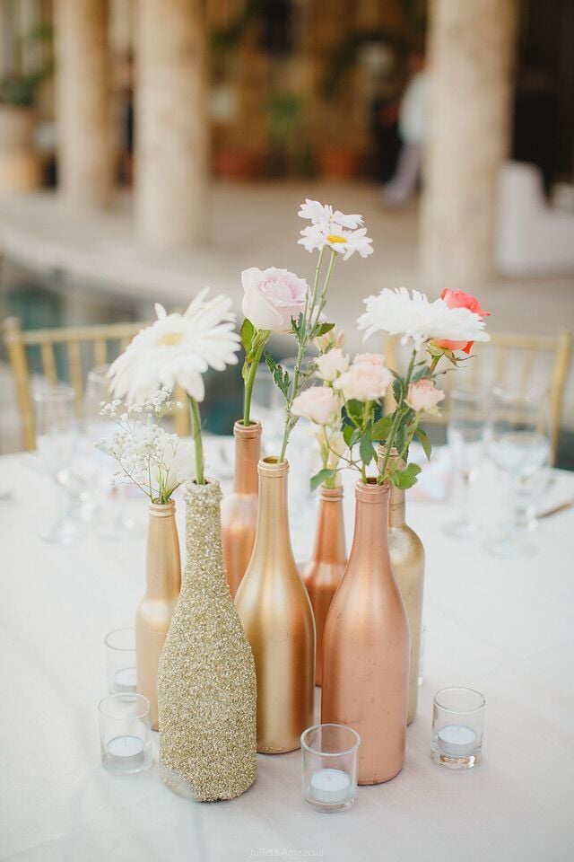 Spray-paint empty bottles in metallic tones for vases. | Gold and