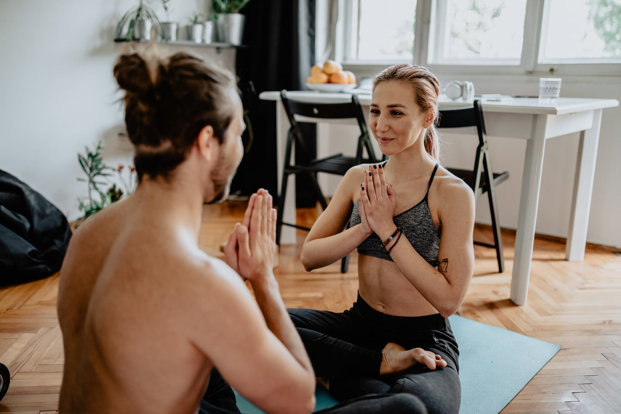 Beautiful young couple doing acroyoga together at home