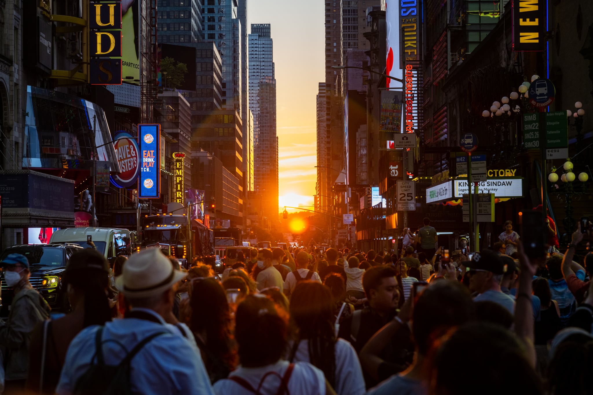 Hundreds of people gather around to watch the sun set during Manhattanhenge in Times Square on July 11, 2022