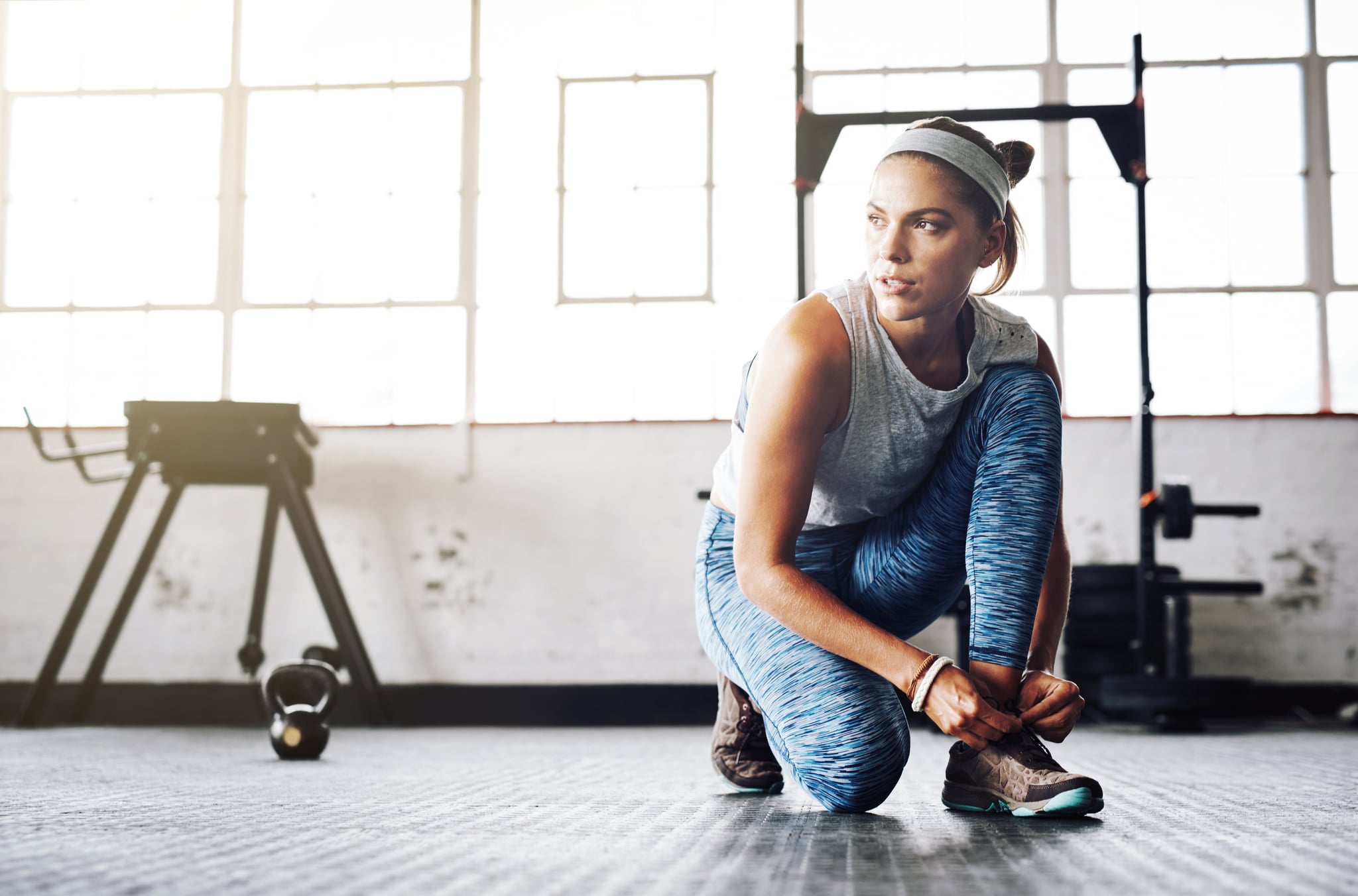 Shot of an attractive young woman tying her shoelaces at  the gym